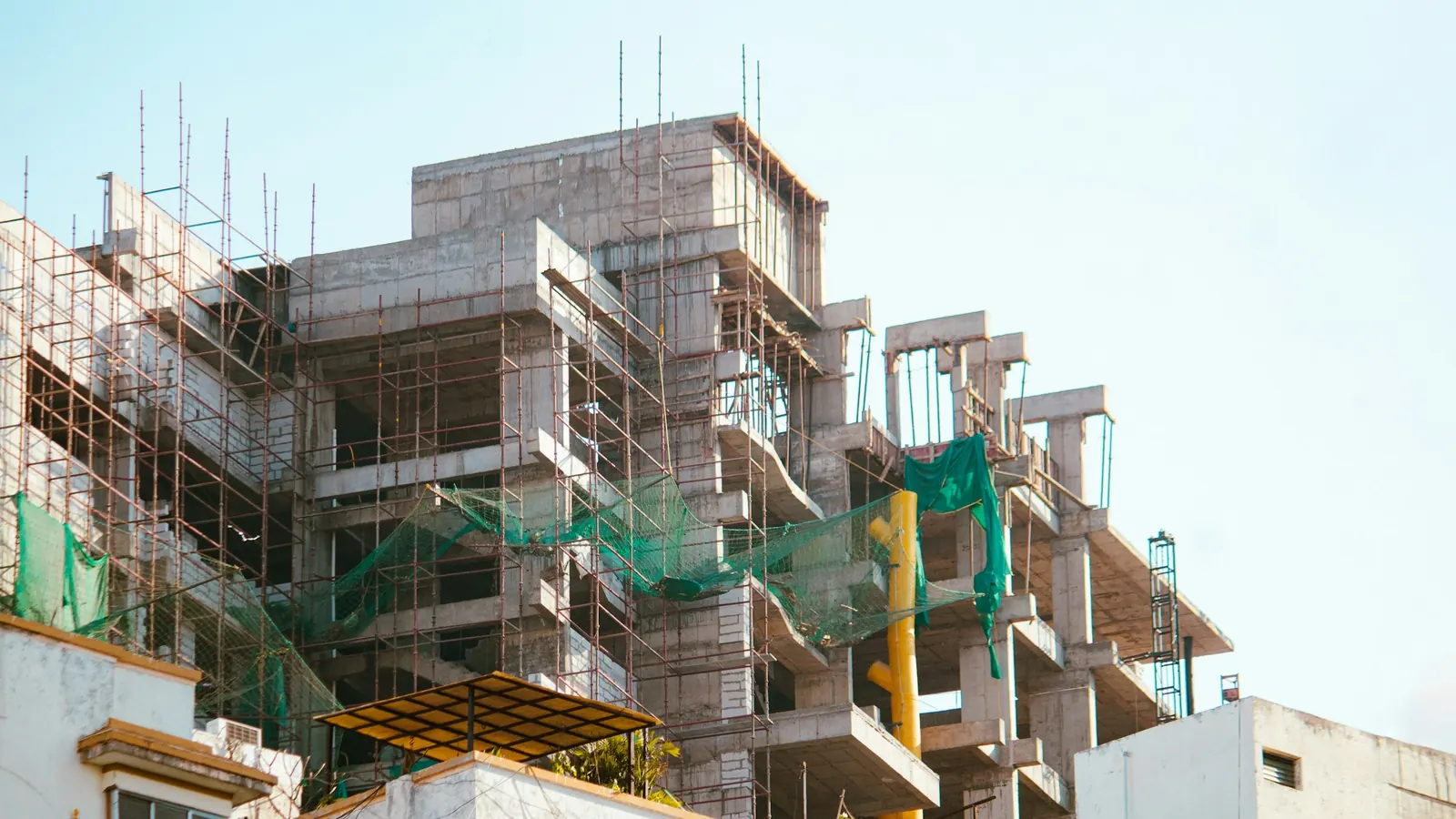 Reinforced concrete building under construction with bamboo and steel scaffolding